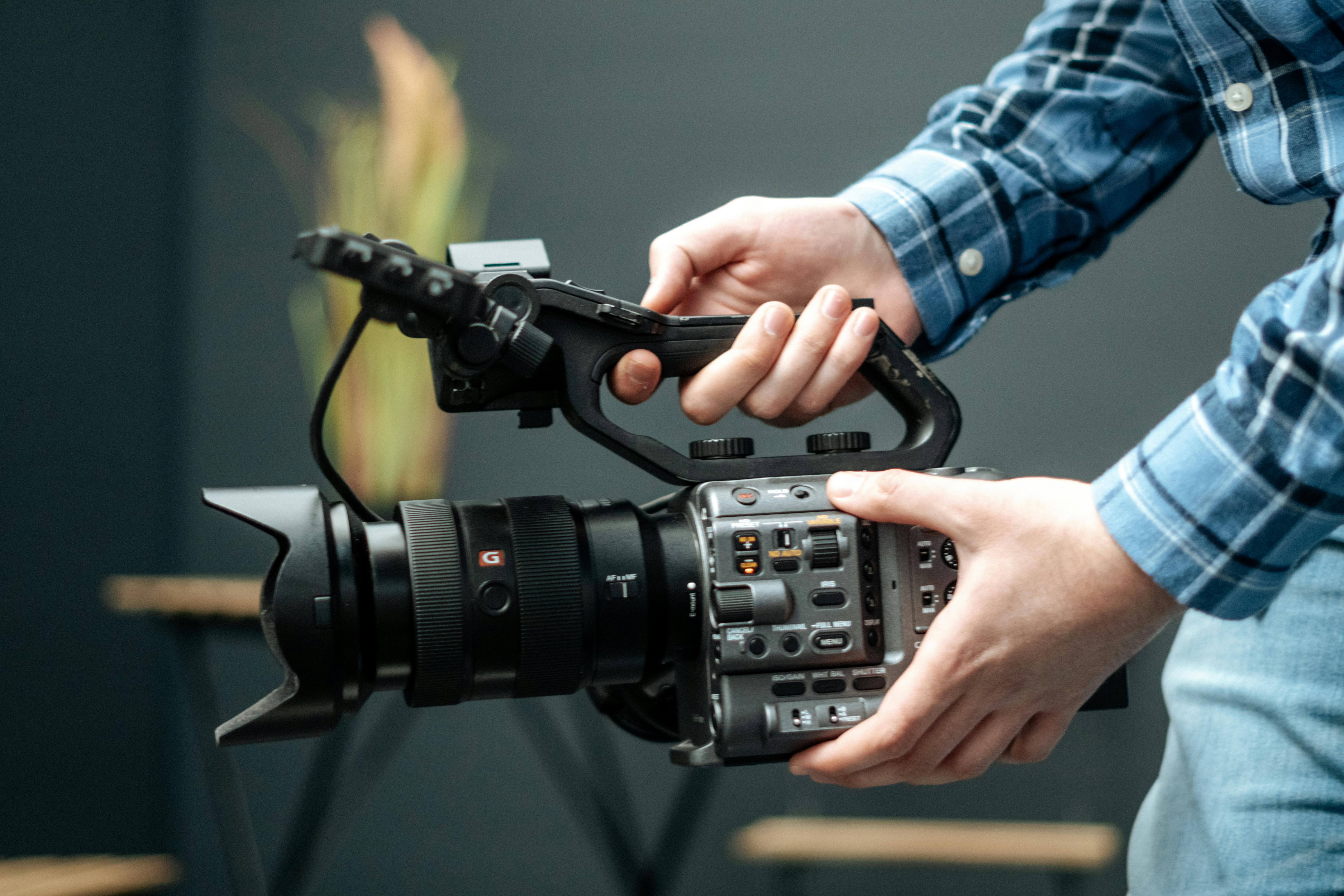 a camera, lens, microphone, and lighting equipment arranged on a table, ready for a film shoot.