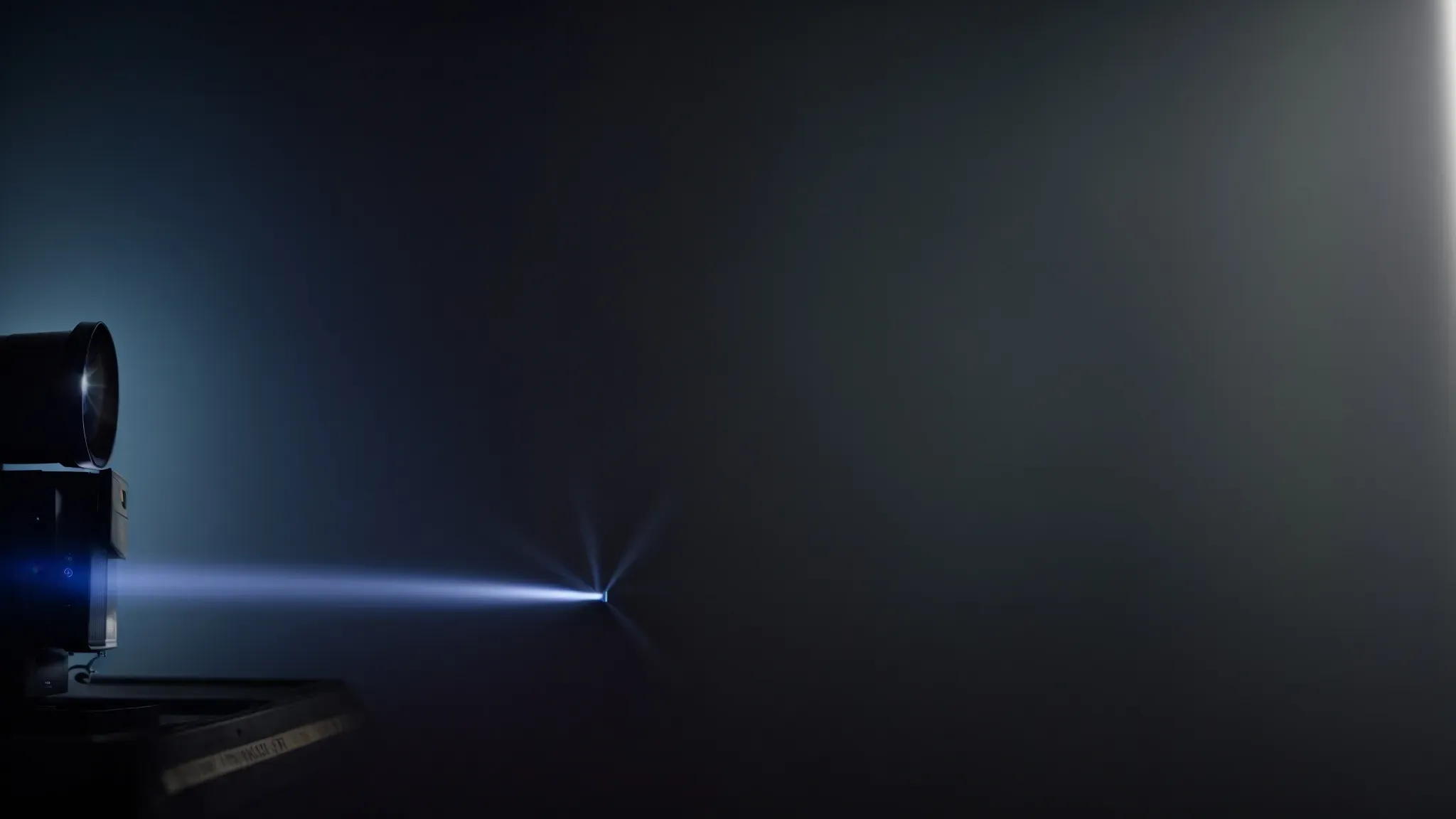 a projector casting light onto an empty cinema screen in a dark room.