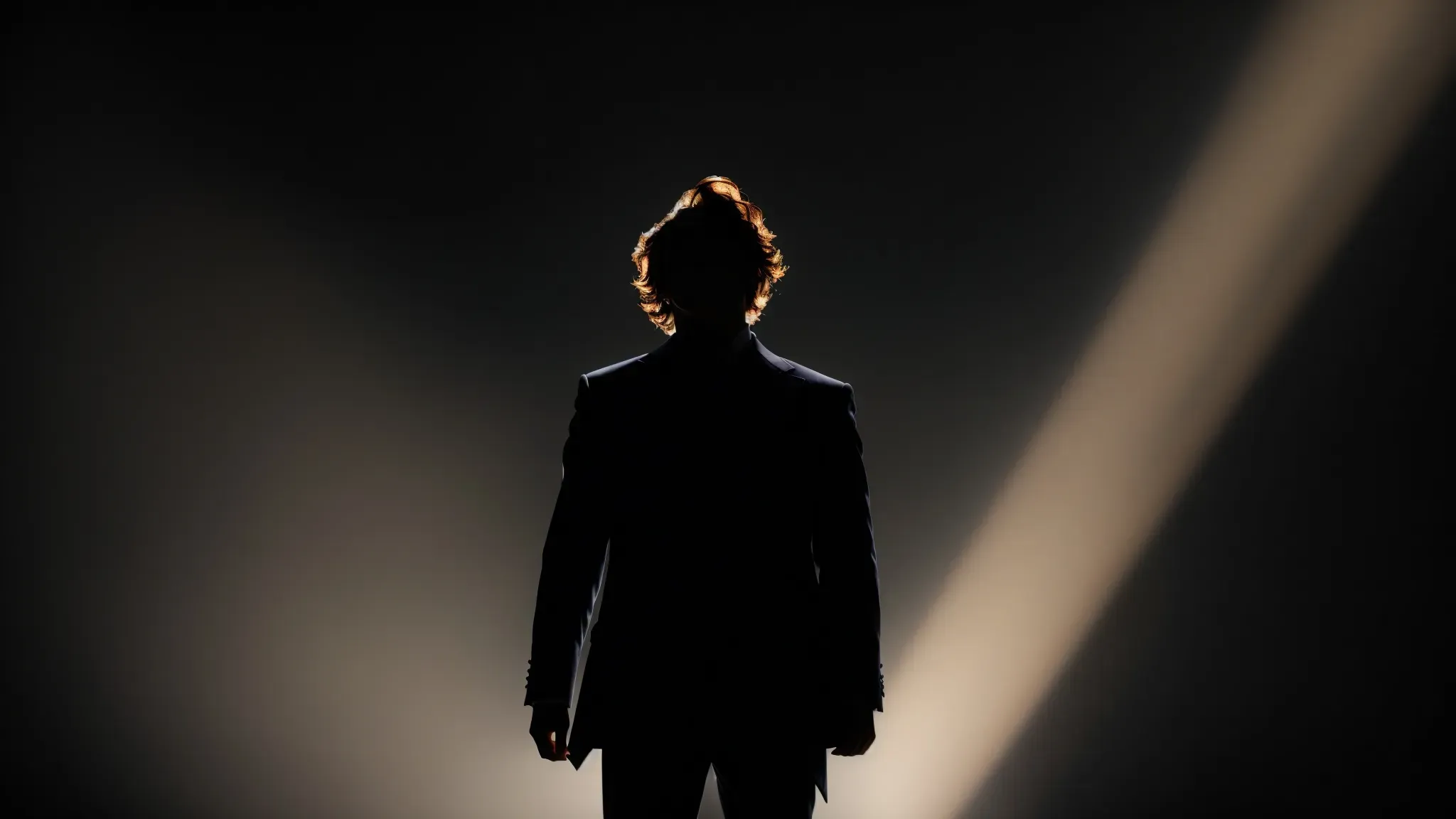 a silhouette of a joker figure standing in the spotlight on an empty stage, laughing into the darkness.