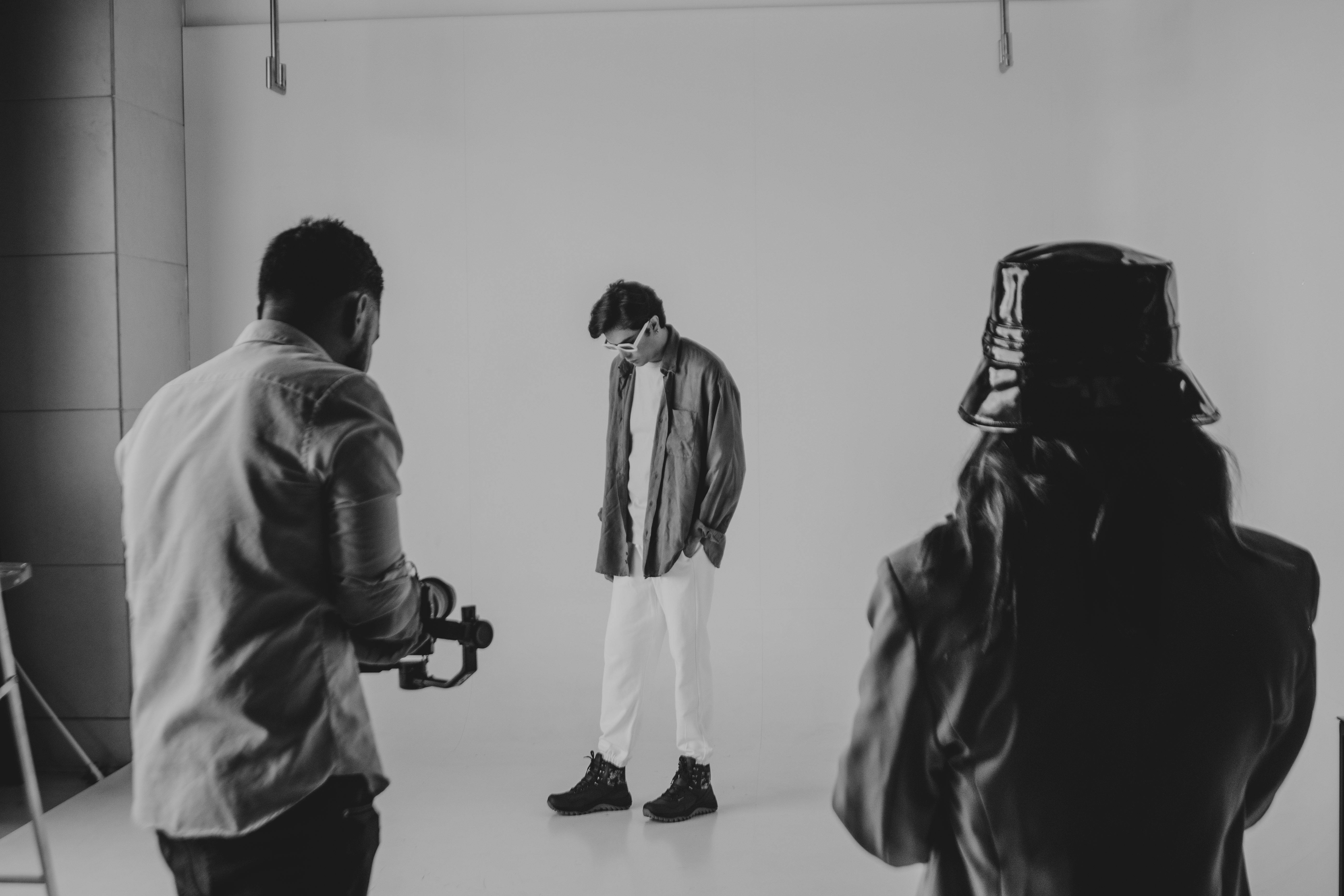 a photographer tours an expansive, well-lit studio, surrounded by various professional lighting setups and a selection of backdrops.