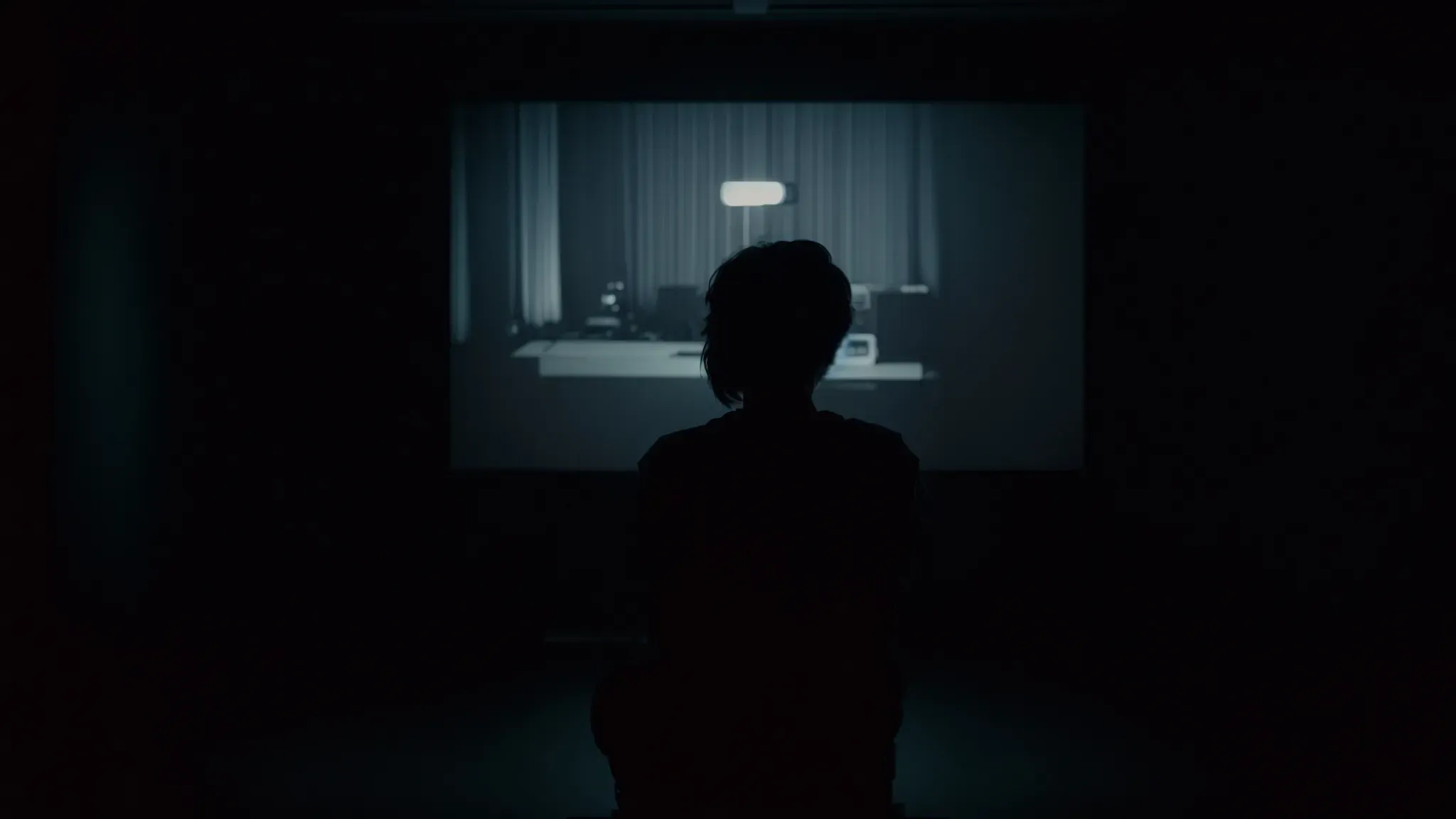 a silhouette of a person sitting in a dark room illuminated only by the flickering light of a classic animated movie playing on an old-fashioned projector screen.