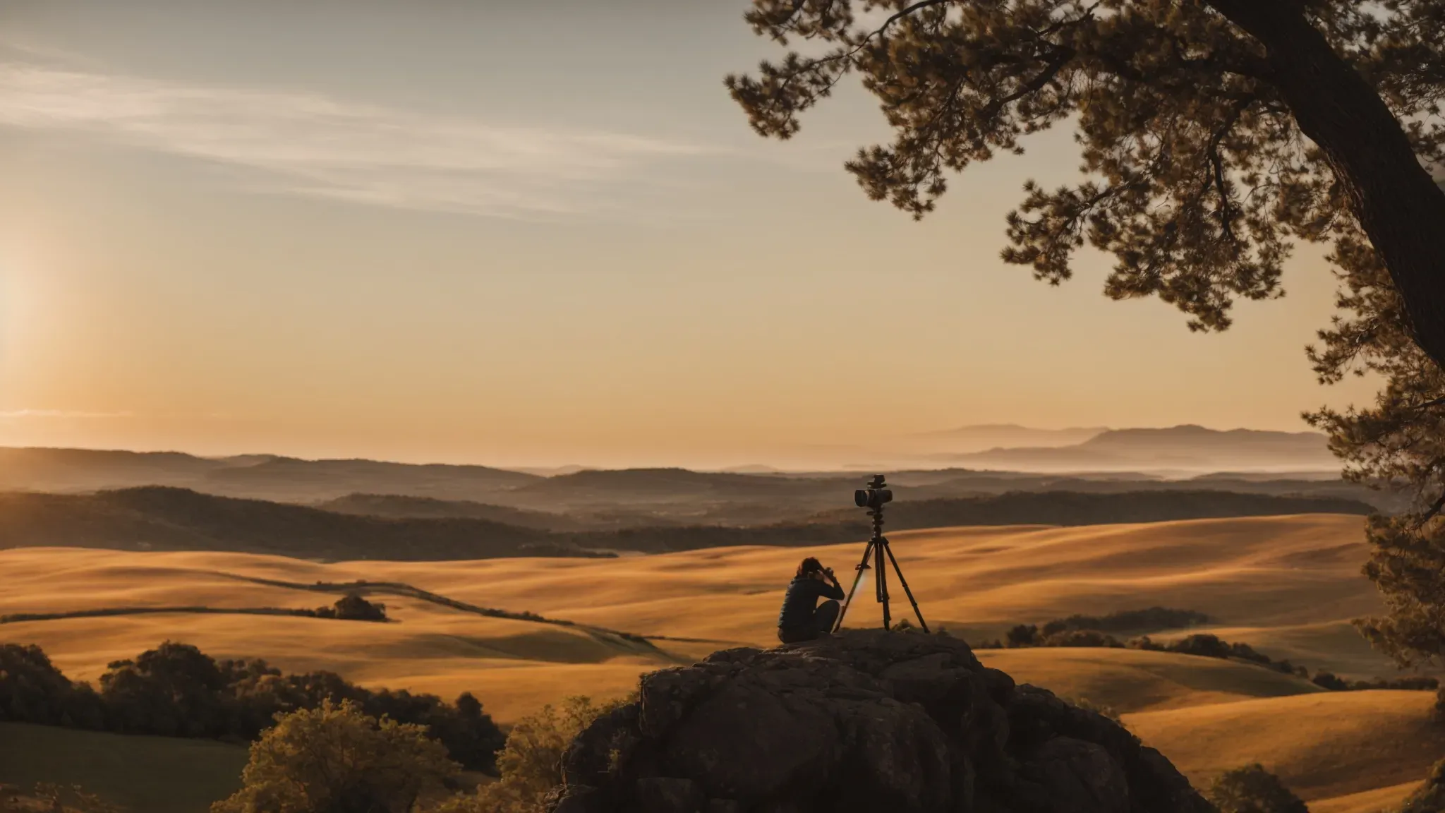 a person adjusting a camera on a tripod overlooking a scenic landscape at golden hour, capturing the perfect shot.