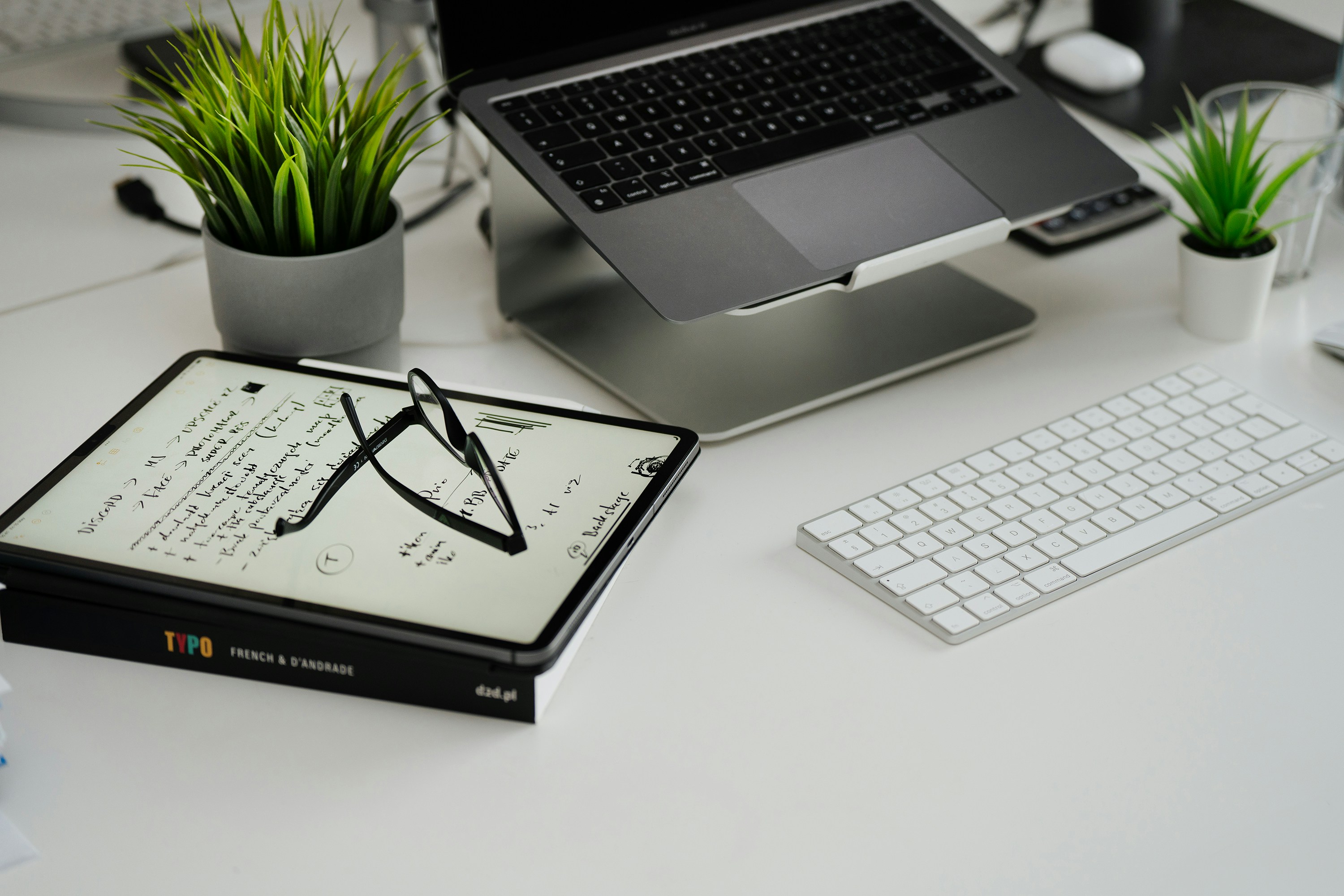 a planner, calculator, and laptop displaying charts and graphs are arranged on a table, symbolizing the use of technology in construction budget management.