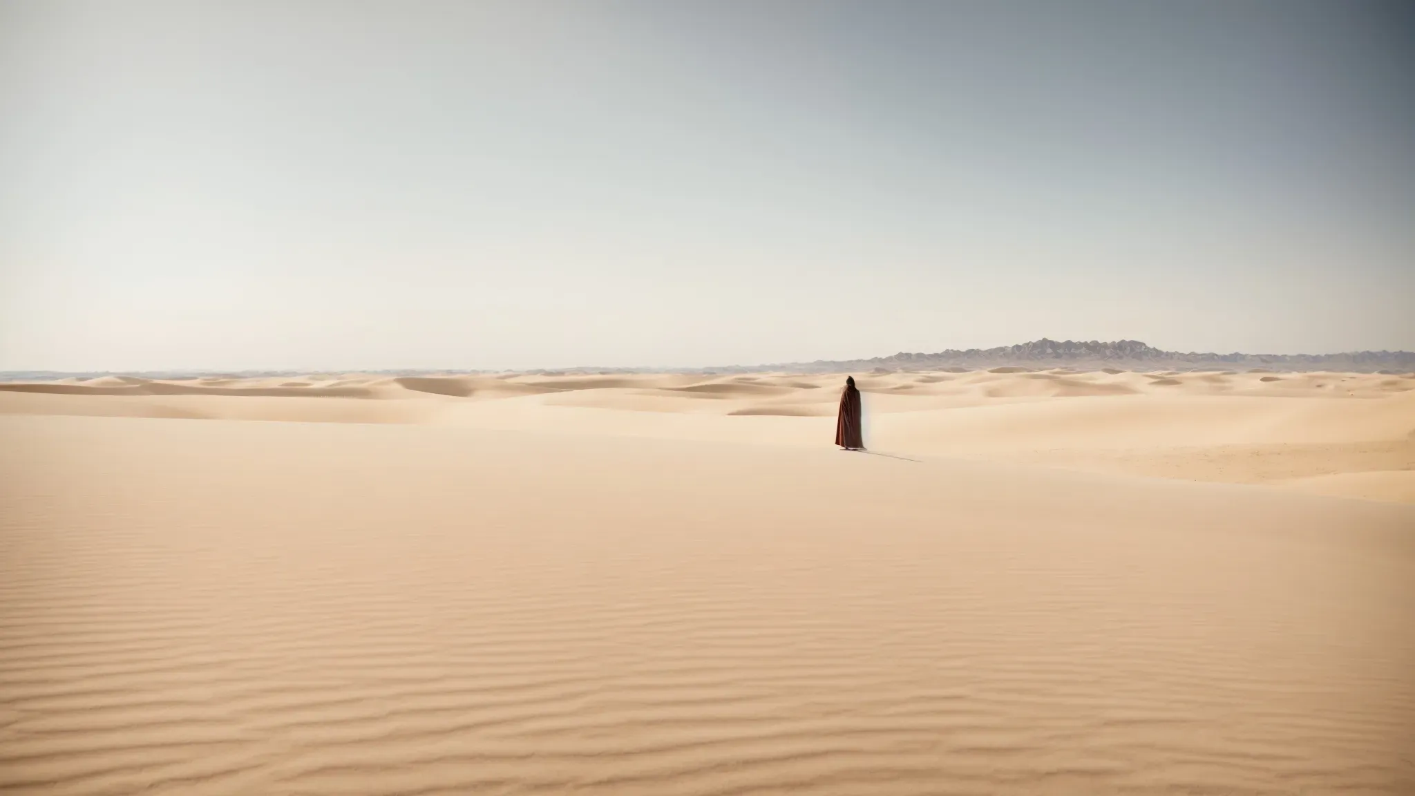 a solitary figure stands dwarfed by the vast, open desert stretching endlessly under a clear sky.