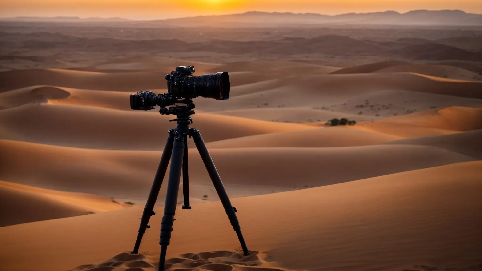 a camera on a tripod overlooks a vast, empty desert at sunset, capturing the golden hues sprawling towards distant mountains.
