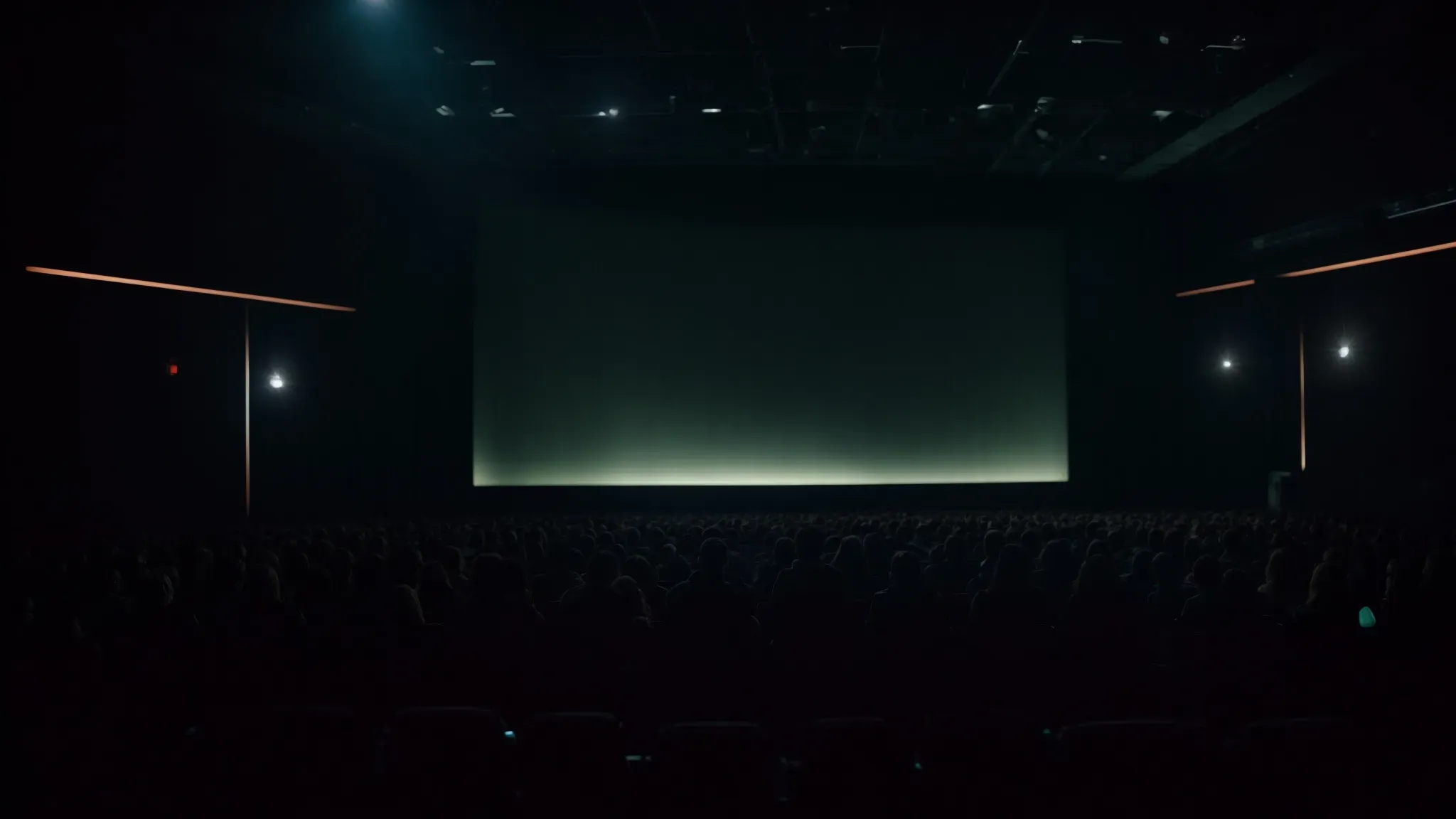 a scene showcasing a dark cinema room lit by the glowing credits rolling on a vast screen, with audiences silhouetted against the bright backdrop.