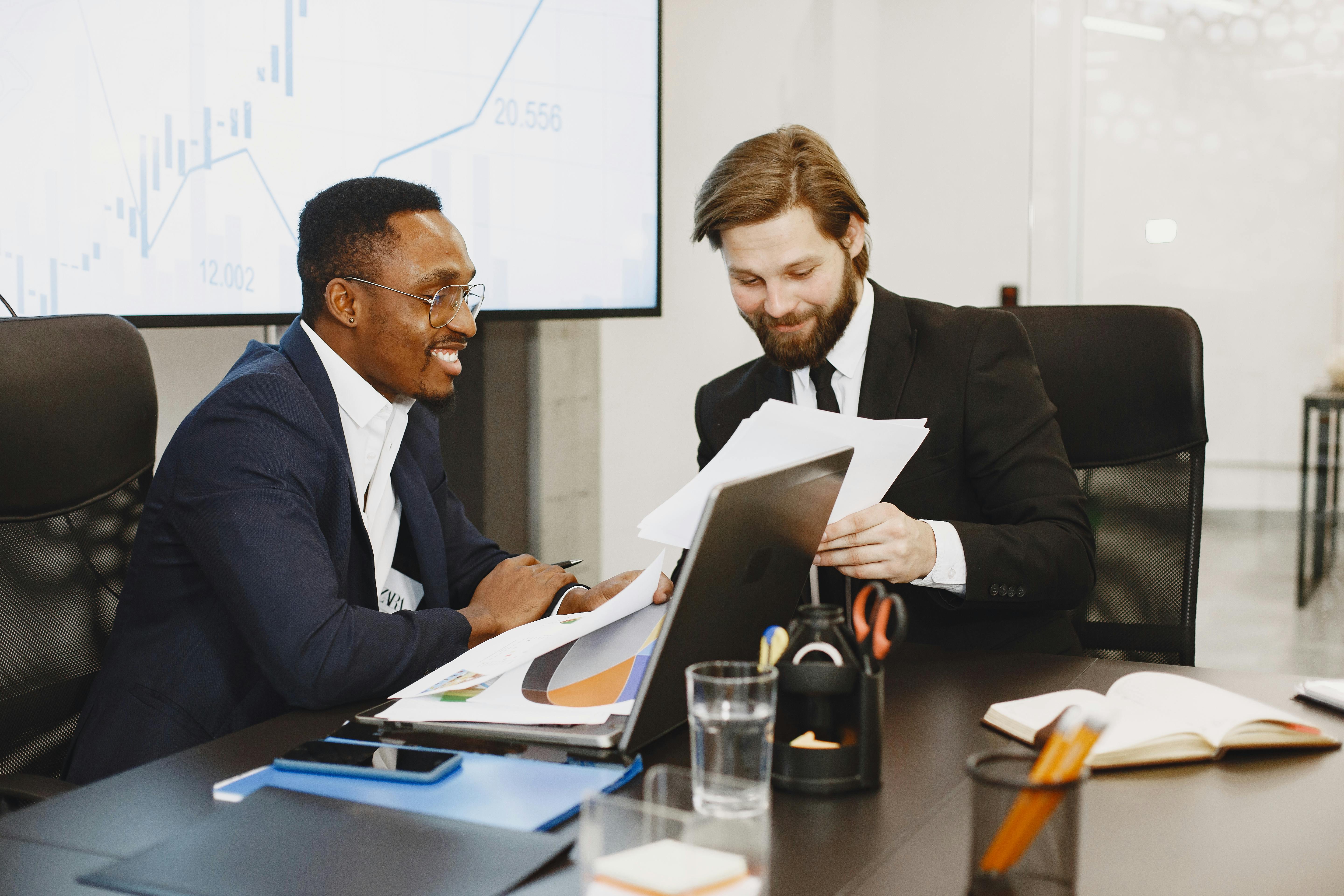 an agent and actor sit across from a film producer in a meeting room discussing a contract.