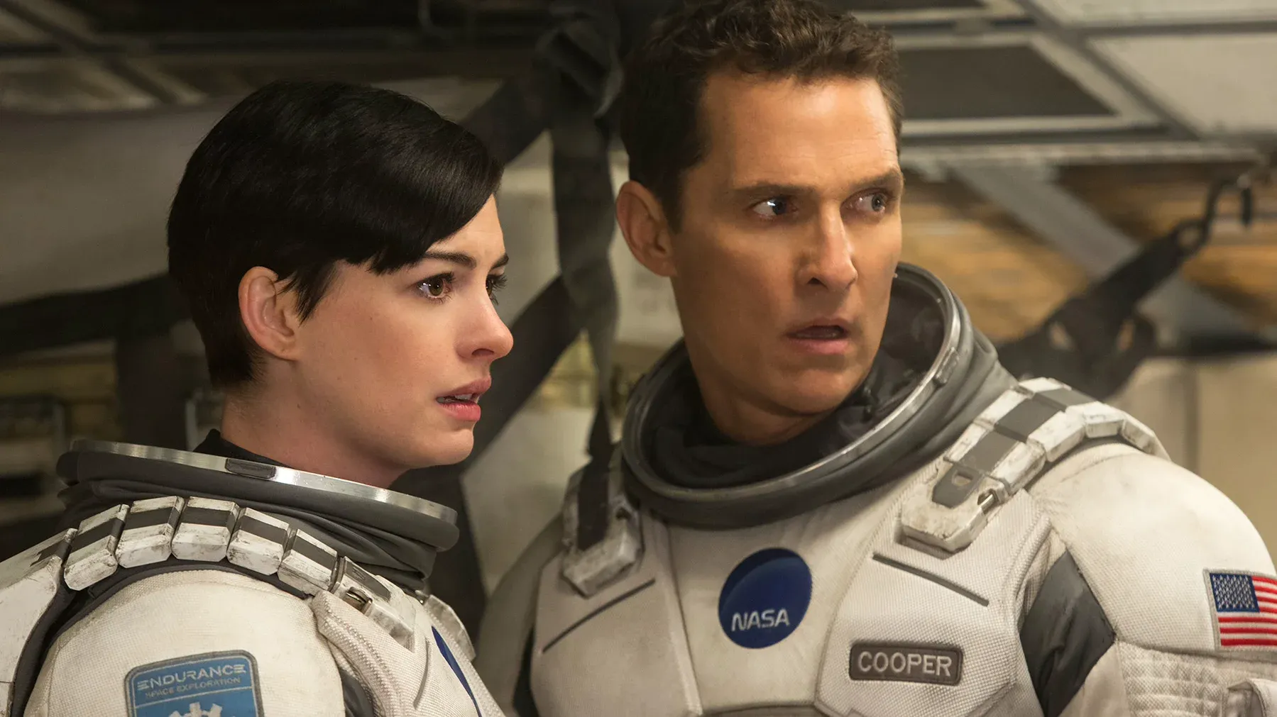 a starry expanse envelopes a spacecraft as it approaches a gargantuan, swirling wormhole, against the infinite darkness of space.